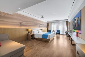 昆明市にあるRamada Encore by Wyndham Kunming Guanduのベッドと机があるホテルの部屋 +37枚の写真