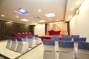 a meeting room with blue chairs and a red couch at Hotel Avexia Premiere, Agra in Agra