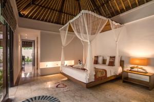 a bedroom with a bed with a mosquito net at Sayang Garden & Pool Vllla Ubud in Ubud