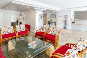 a living room with chairs and a glass table at Belle Escapes 101 Rydges Plaza Esplanade with Panoramic Ocean Views in Cairns