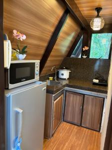 eine Küche mit einem Kühlschrank und einer Mikrowelle in der Unterkunft Kembali coast resort A-house style in Caliclic