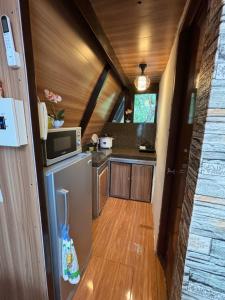 eine kleine Küche mit einem Kühlschrank und einer Mikrowelle in der Unterkunft Kembali coast resort A-house style in Caliclic