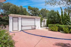 uma garagem branca com duas portas numa entrada em Amazing Villa in Marbella! em Marbella