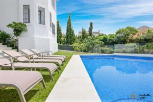 uma piscina com espreguiçadeiras ao lado de uma casa em Amazing Villa in Marbella! em Marbella