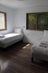 a room with two beds and two windows at קשת בענן in Modi'in-Maccabim-Re'ut