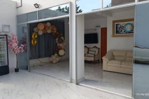 a living room with a glass door with a couch at Casa Piscina Duna Saraja Ica-Perú in Ica