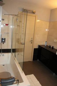a bathroom with a shower and a tub with a sink at קשת בענן in Modi'in-Maccabim-Re'ut