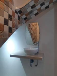 y baño con lavabo y espejo. en Casa Piscina Duna Saraja Ica-Perú, en Ica