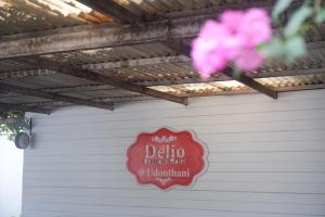 烏隆他尼的住宿－Delio Boutique Hotel，车库边有粉红色花的标志