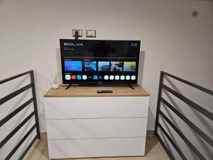 a flat screen tv on top of a white dresser at Casa savoia dream in Naples