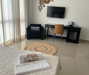 ZARA HOTEL في أنتاناناريفو: غرفة معيشة بها أريكة وطاولة وتلفزيون