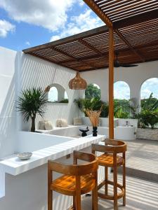 una cocina con 2 sillas y una mesa en el patio en Aesthetic Villa 1bed with private rooftop and pool, Casa Alba, Canggu Pererenan, en Canggu