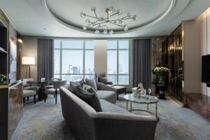 ein Wohnzimmer mit einer Couch und einem Kronleuchter in der Unterkunft Centara Grand At CentralWorld in Bangkok
