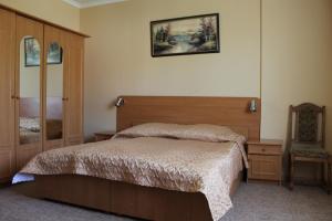 sypialnia z łóżkiem i zdjęciem na ścianie w obiekcie Zakarpattya w mieście Polyana (Polana)