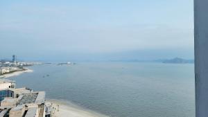 une grande étendue d'eau avec une plage et des bâtiments dans l'établissement Luxury 5star Residence À La Carte HaLong Bay Floor 37, à Hạ Long 98 autres photos