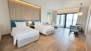 une chambre d'hôtel avec deux lits et un bureau dans l'établissement Luxury 5star Residence À La Carte HaLong Bay Floor 37, à Hạ Long