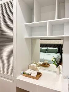 a white bedroom with a bed in a mirror at Home in Ho Chi Minh City, D1 in Ho Chi Minh City