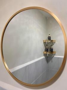 un espejo redondo en una pared con dos estanterías en Clarity’s Staycation en Basbas