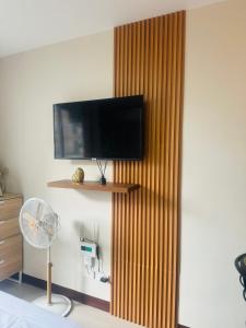 um quarto com uma televisão montada na parede e uma ventoinha em Clarity’s Staycation em Basbas