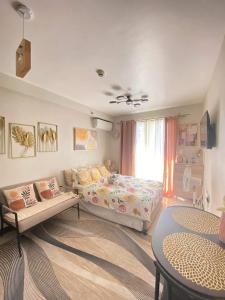 1 dormitorio con cama, sofá y mesa en Clarity’s Staycation en Basbas