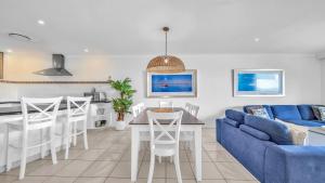 ハミルトン島にあるLagoon Beachfront Lodge 202 on Hamilton Island by HamoRentのリビングルーム(青いソファ、テーブル付)