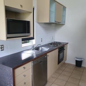 eine Küche mit einer Spüle und einer Mikrowelle in der Unterkunft Kuirau Chalet Villa 3-bedroom Twin Lake in Rotorua