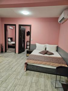 a bedroom with a bed and a pink wall at Апартамент България със свободна зона за паркиране in Veliko Tŭrnovo