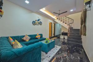 a living room with a blue couch and stairs at EMPYREAN STAY ll 3BHK II MARSHAL VILLA II AC II BIG POOL ll LUXURY II in Lonavala