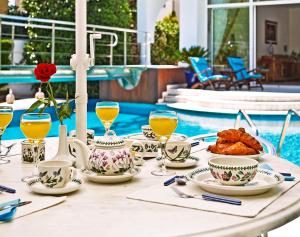 uma mesa com comida e bebidas junto a uma piscina em Villa Stefani with Private Pool em Atenas