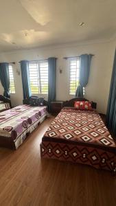 2 Betten in einem Zimmer mit blauen Vorhängen in der Unterkunft Aspire Homestay in Siem Reap