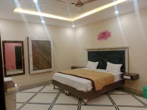 ein Schlafzimmer mit einem Bett in einem Zimmer in der Unterkunft Hotel Rudra Palace in Khajurāho