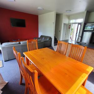 a dining room with a wooden table and chairs at Kuituna on the Canal Villa, 3 bedrooms in Rotorua
