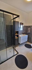 bagno con doccia in vetro e lavandino di Appartamento Pedavena a Pedavena