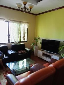 sala de estar con sofá y TV en Villa Ceferina en Tagbilaran City