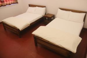 duas camas num quarto com lençóis brancos em Mountain View Holidays em Colombo