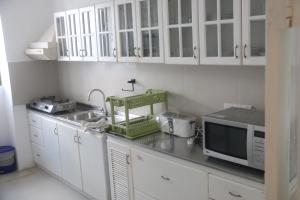 cocina con armarios blancos y microondas en Mountain View Holidays, en Colombo