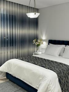 a bedroom with a large bed and a gray wall at Misk Villa - Boutique Hotel & Spa in Sidi Bou Saïd