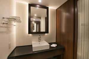 a bathroom with a sink and a mirror at Grand Mercure Okinawa Cape Zanpa Resort in Yomitan