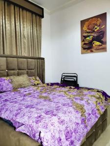 um quarto com uma cama com um edredão roxo em 3 bedrooms with Modern Amenities em Abeokuta