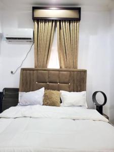 um quarto com uma grande cama branca e uma janela em 3 bedrooms with Modern Amenities em Abeokuta