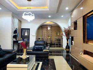 a living room with black leather furniture and a chandelier at 3 bedrooms with Modern Amenities in Abeokuta
