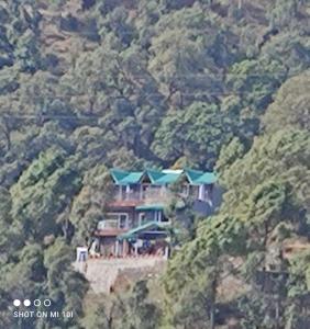 una casa con techos azules en una montaña en Himalayan Magpie Homestay Bhimtal, en Bhimtal