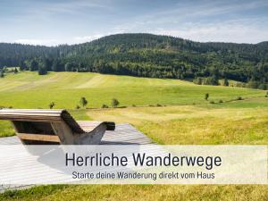 een uitzicht op een veld met een wandelbordje van Farmhousearma bij Fewo Herzgrün mit Balkon und Traumblick direkt an Wanderwegen und Sauna im Haus in Todtnauberg