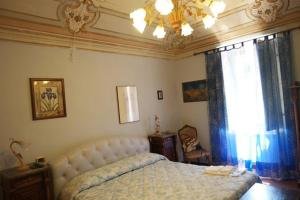 - une chambre avec un grand lit et un lustre dans l'établissement Antica Dimora Fuori Le Mura B&B, à Scanno