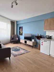 a living room with blue walls and a kitchen at Allegro Apartments Kadıköy in Istanbul