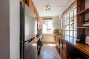 a kitchen with a stainless steel refrigerator and a window at Quaint 3 BDR Beach Bungalow in a fishing village in Grand Gaube