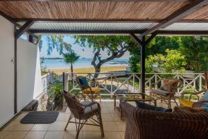 a patio with chairs and a view of the ocean at Quaint 3 BDR Beach Bungalow in a fishing village in Grand Gaube