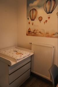 Auszeit am Land في Kemnath: غرفة نوم صغيرة بسرير وصورة بالونات هواء حار