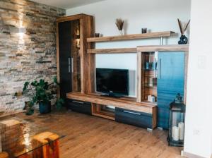 a living room with a large entertainment center with a television at Auszeit am Land in Kemnath