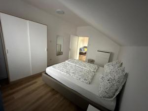 een slaapkamer met een bed met witte lakens en kussens bij Appartamento "Rio Nero" in Ora/Auer